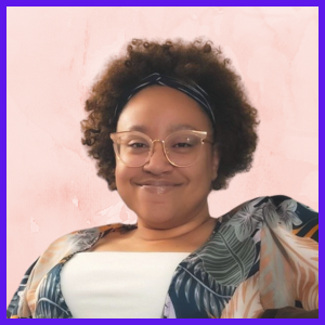 A smiling woman with short, curly, brown hair and peach-colored glasses