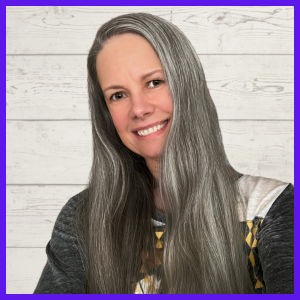 A smiling mixed-Indigenous woman with long, silver-dark hair